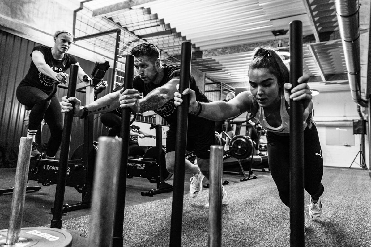 A team pushing sleds together in a coach-led session