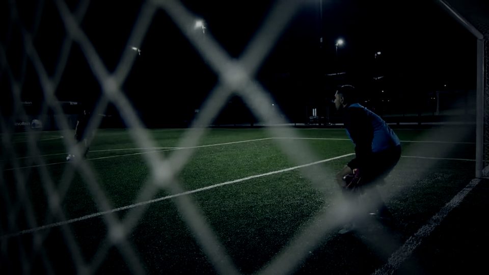 Player training under the lights seen through the goal net
