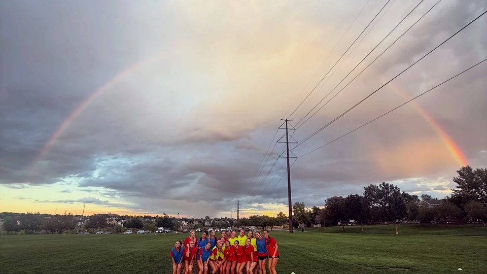 REAL Colorado team on the field under a rainbow