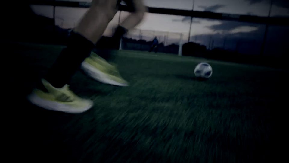 Player sprinting onto a ball at dusk