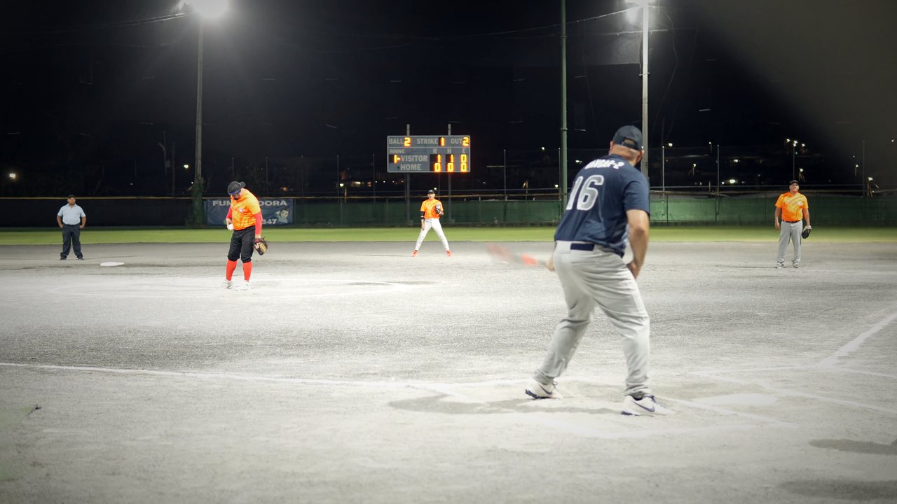 Hitter swinging under the lights